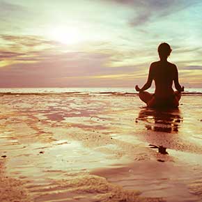 Woman meditating on Beach